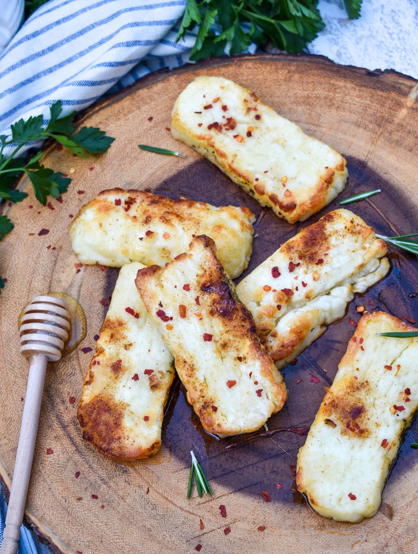 slices of air fried halloumi cheese on a wooden cutting board
