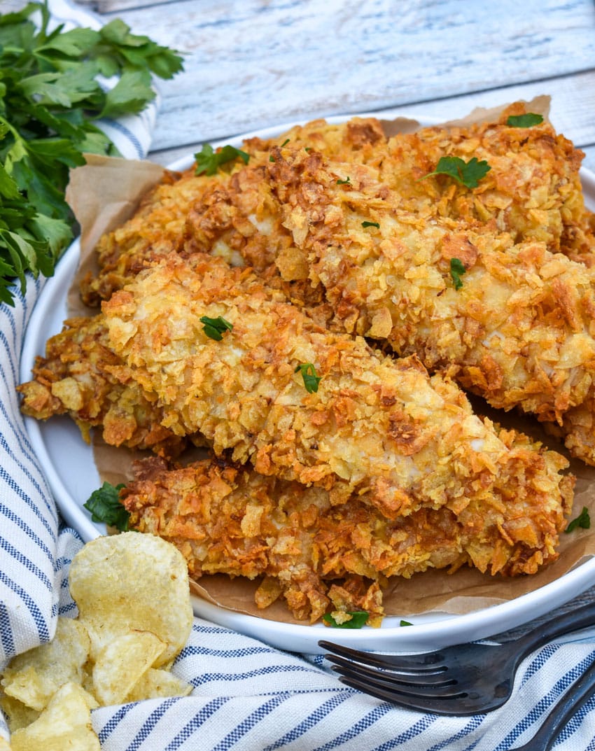 air fryer potato chip chicken tenders stacked on a white plate
