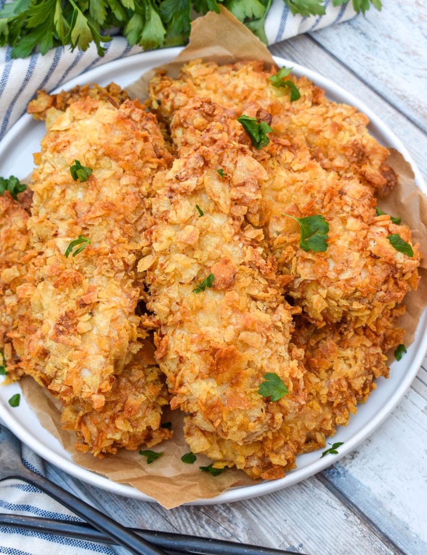 air fryer potato chip chicken tenders stacked on a white plate