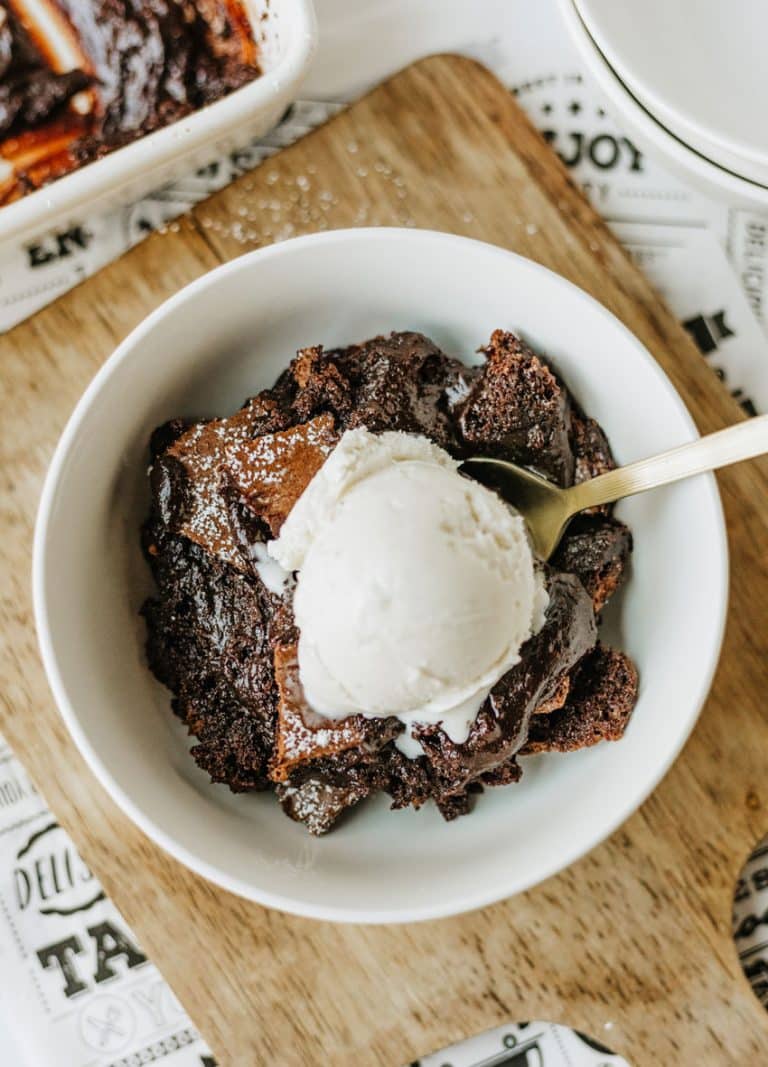 ina garten's brownie pudding topped with a scoop of vanilla ice cream in a white bowl
