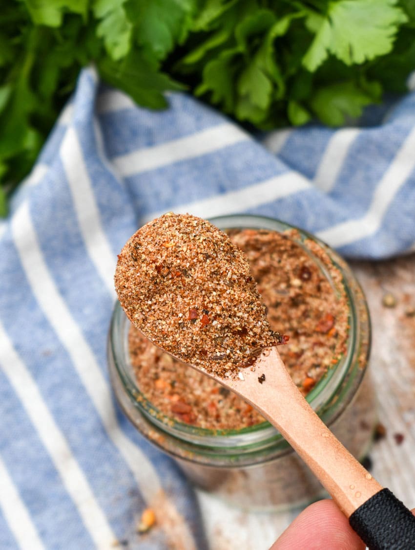 a small wooden spoon holding up a scoop of homemade montreal steak seasoning