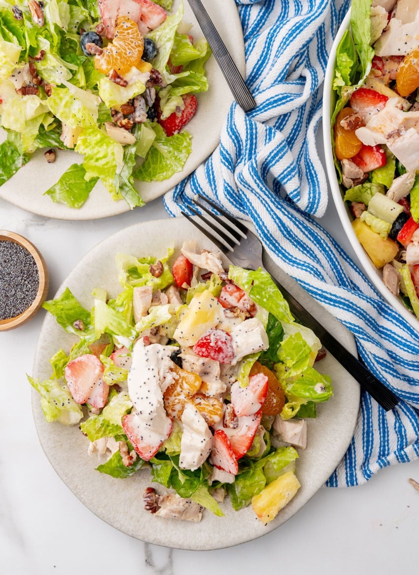 Copycat Panera strawberry poppyseed chicken salad on a small white plate with a black fork resting on the side