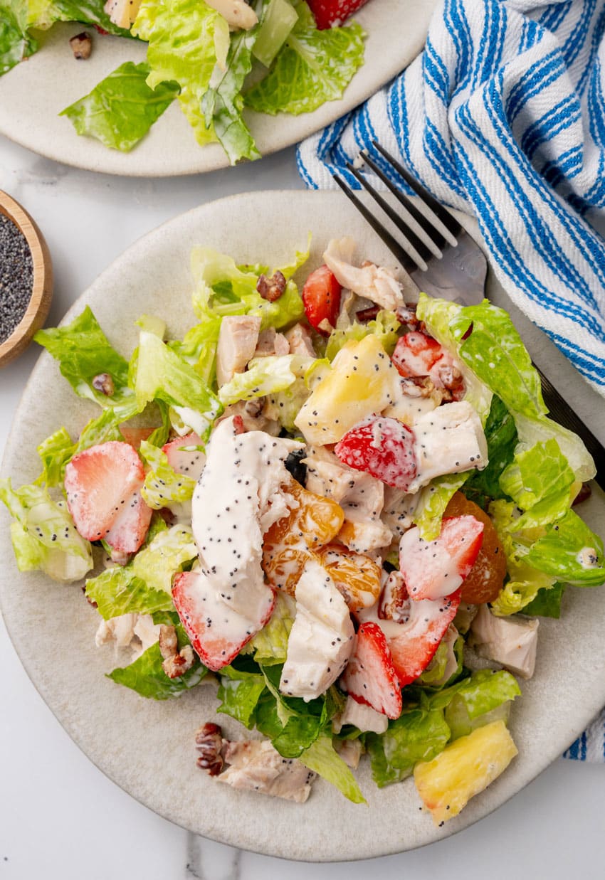 Copycat Panera strawberry poppyseed chicken salad on a small white plate with a black fork resting on the side