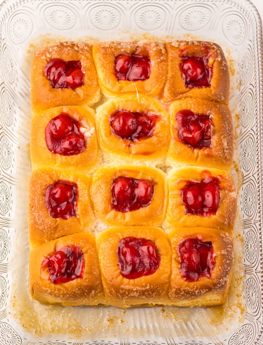 cherry pie filling stuffed sweet hawaiian rolls in a glass baking dish