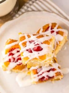 cherry danish hawaiian rolls stacked on a small white plate