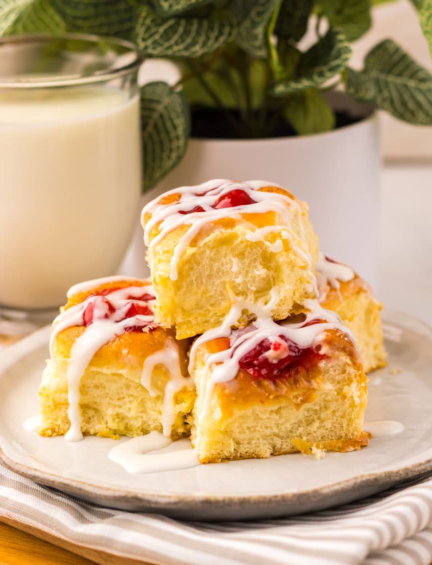 cherry danish hawaiian rolls stacked on a small white plate