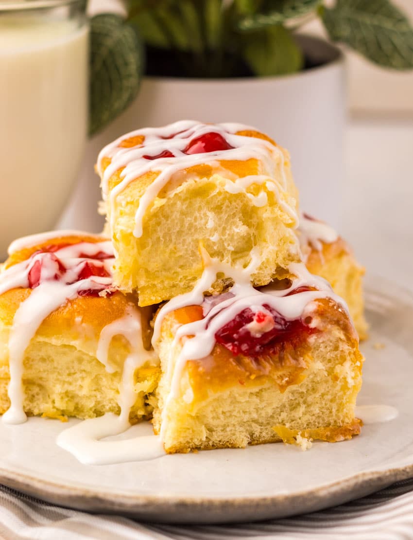 cherry danish hawaiian rolls stacked on a small white plate