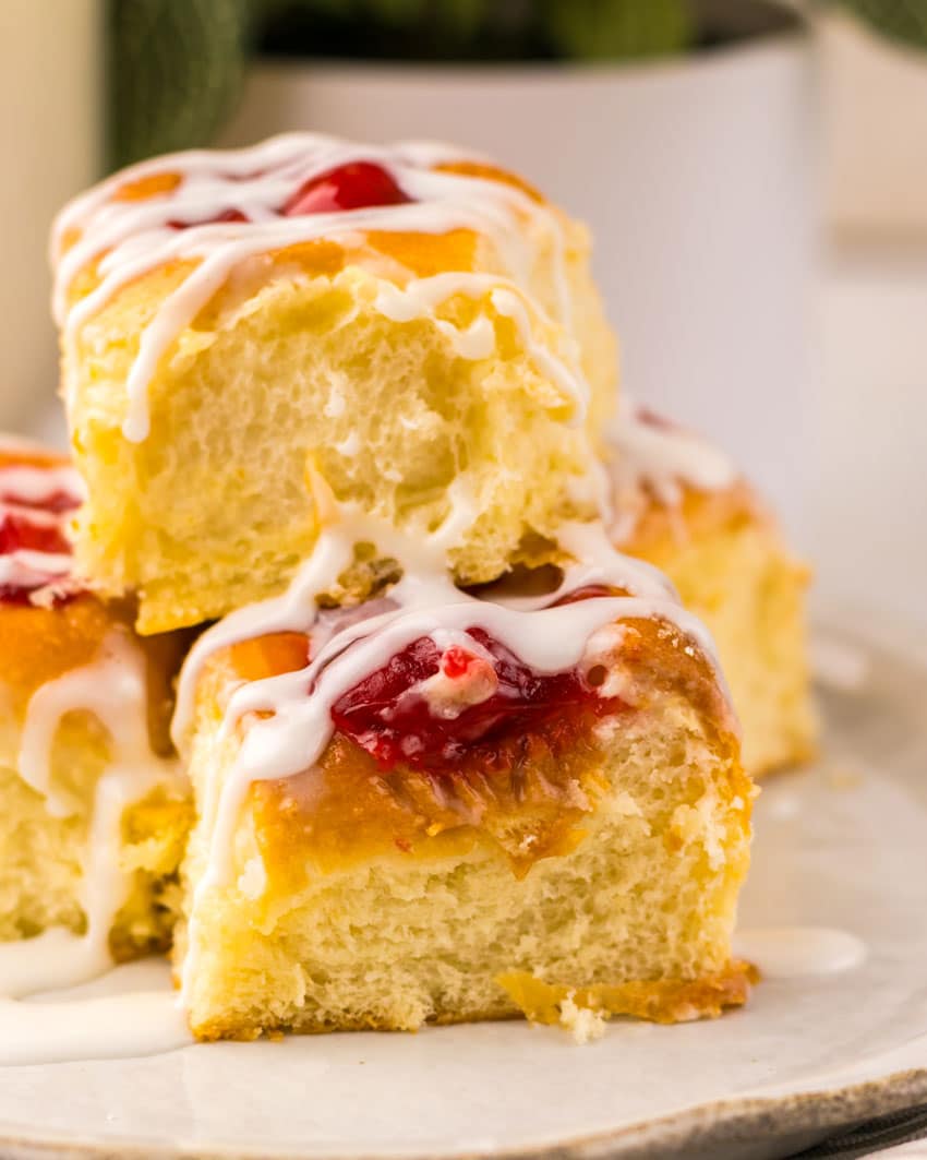 cherry danish hawaiian rolls stacked on a small white plate