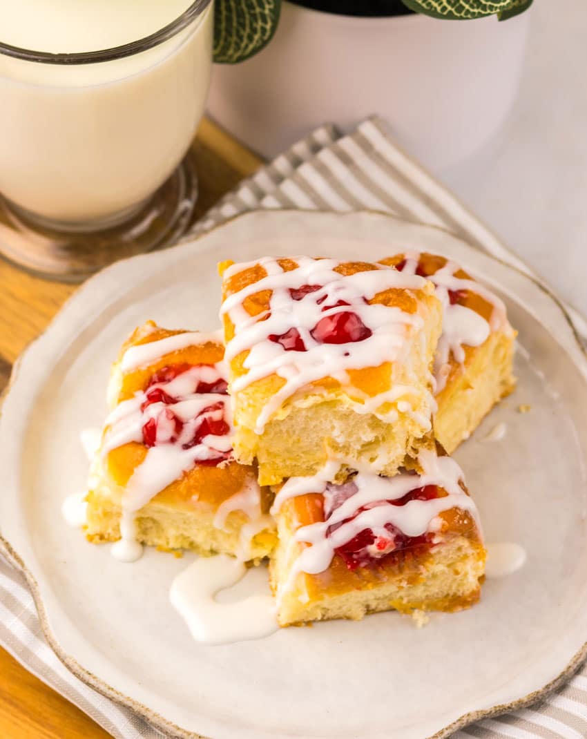 cherry danish hawaiian rolls stacked on a small white plate