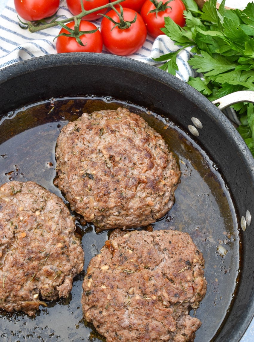 gyro seasoned lamb burger patties in a black skillet