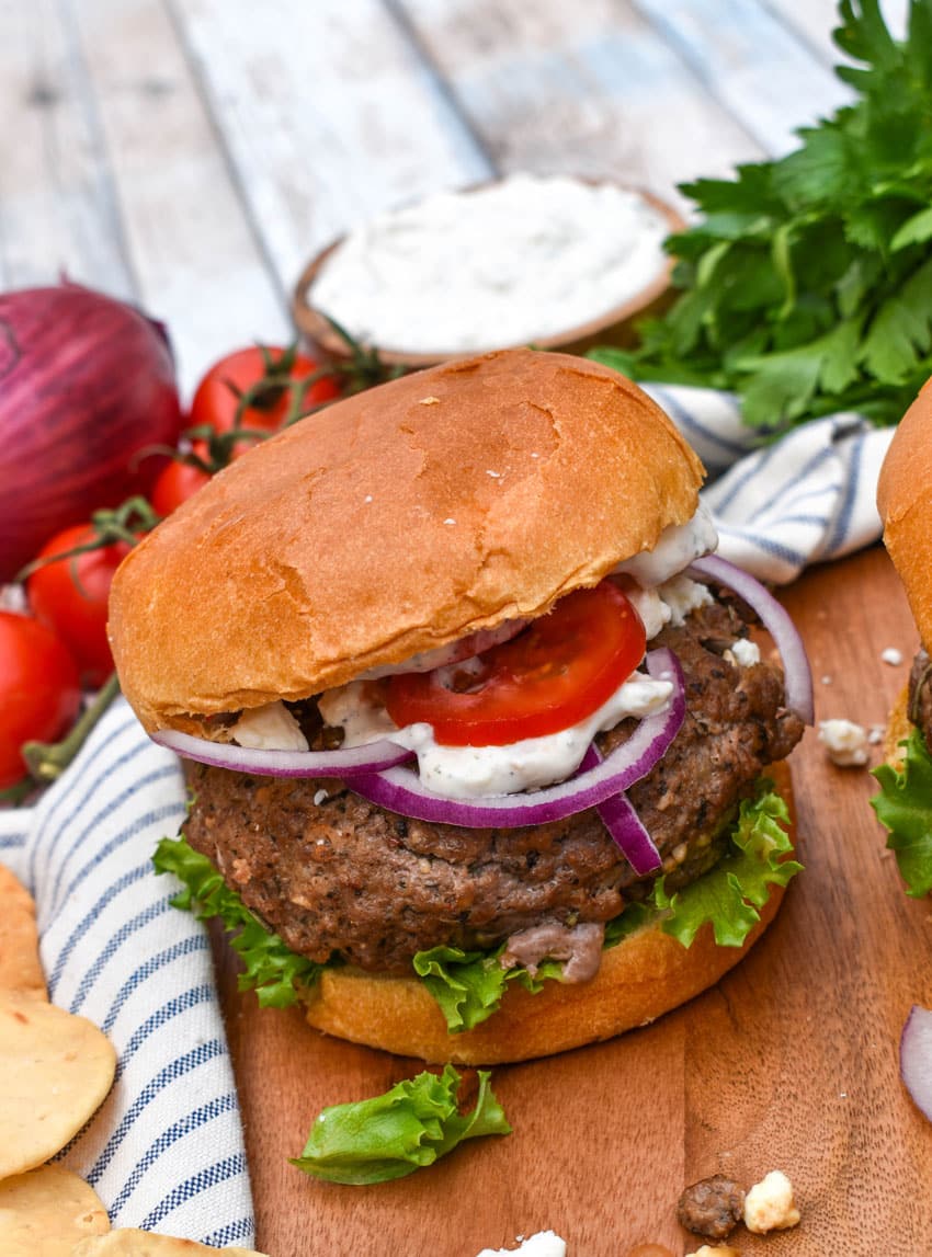 a homemade gyro burger on a wooden cutting board