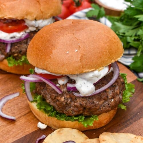 a homemade gyro burger on a wooden cutting board
