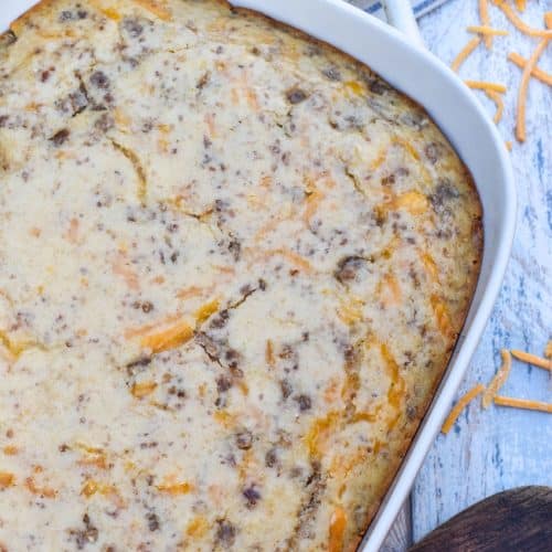 a mcgriddle breakfast casserole in a white baking dish with shredded cheese scattered around the sides