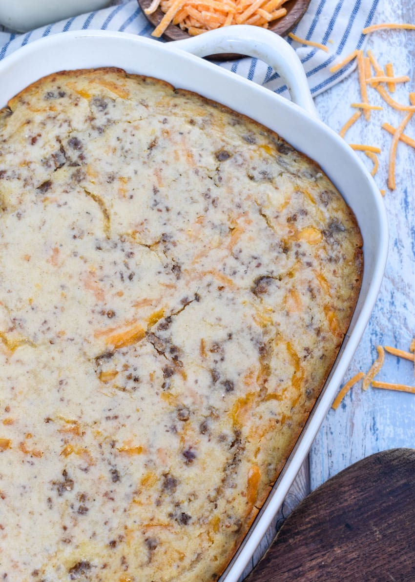 a mcgriddle breakfast casserole in a white baking dish with shredded cheese scattered around the sides