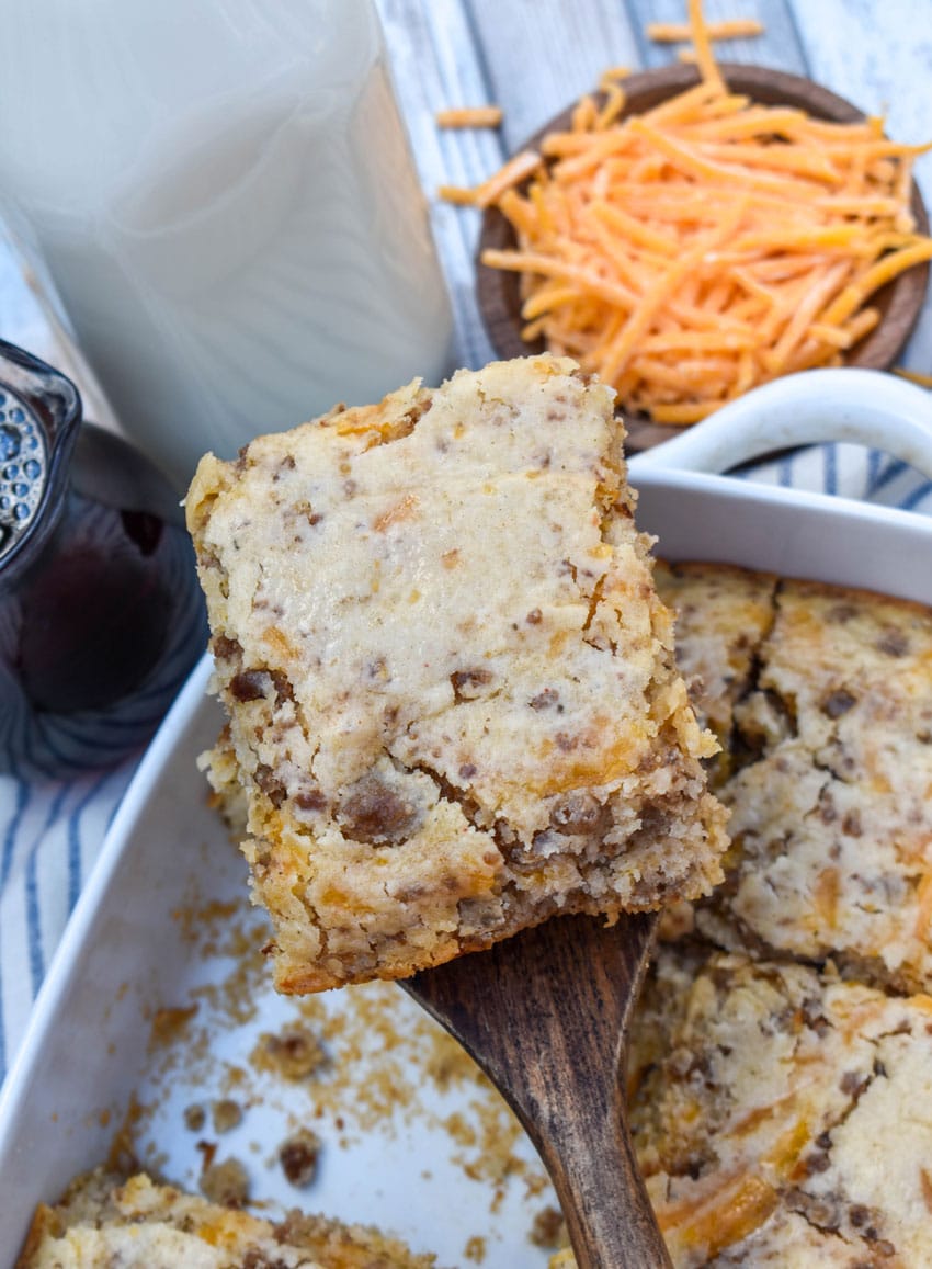 a wooden spatula lifting up a thick slice of a homemade mcgriddle breakfast casserole