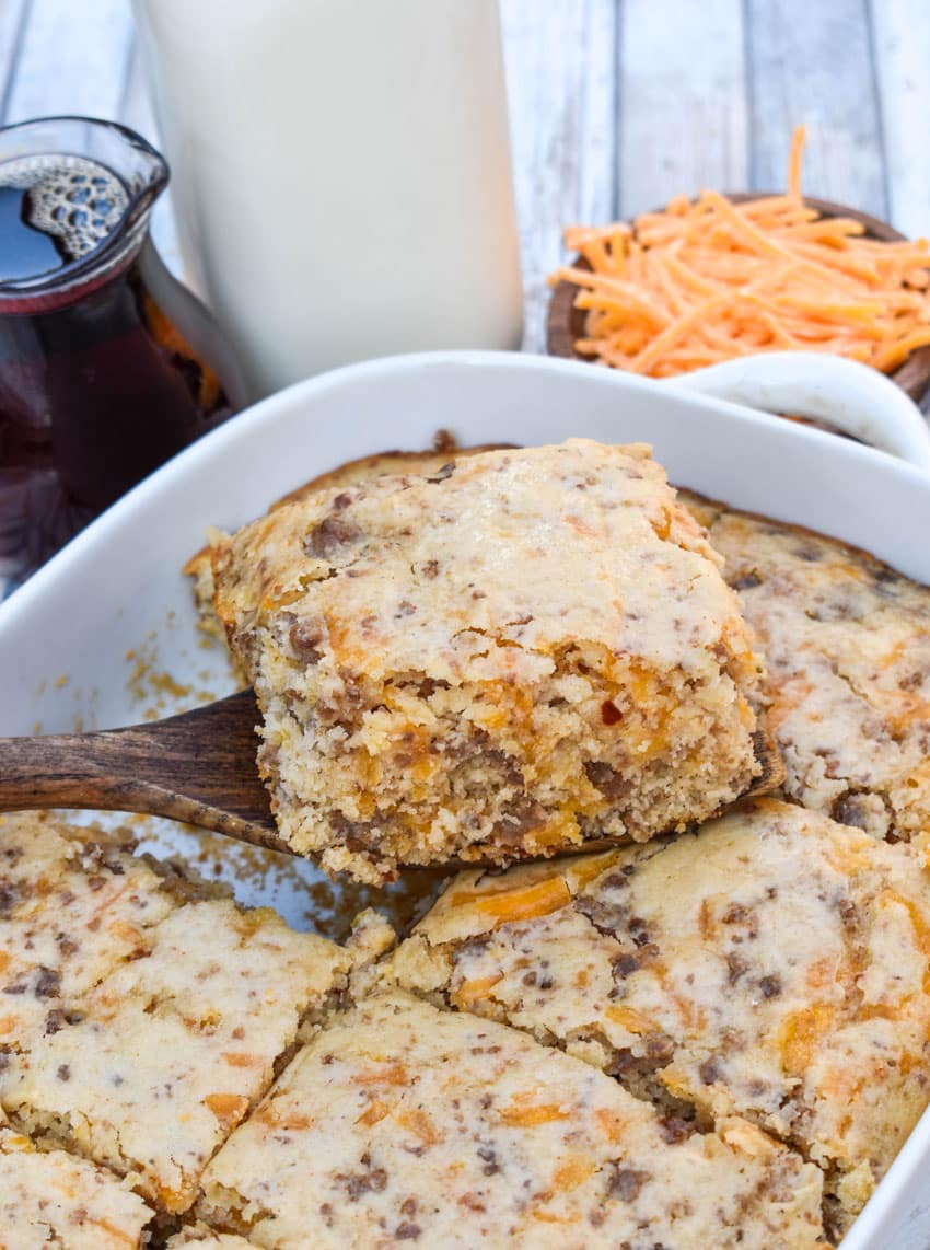 a wooden spatula lifting up a thick slice of a homemade mcgriddle breakfast casserole