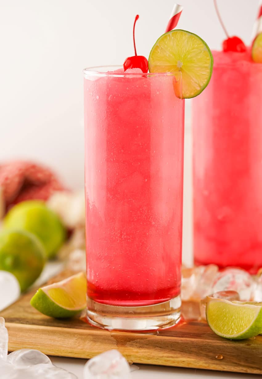 frozen dirty shirley's in two small glasses on a wooden cutting board