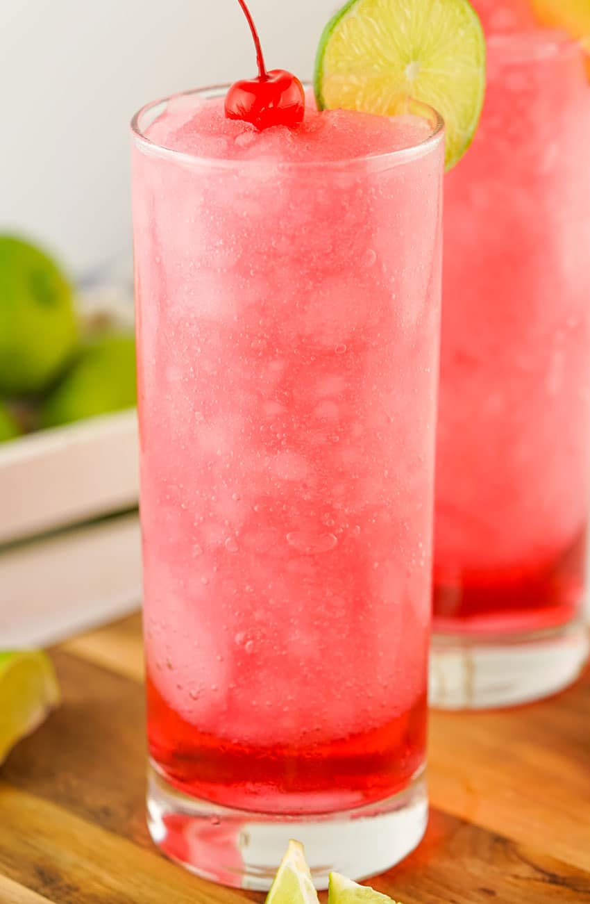 frozen dirty shirley's in two small glasses on a wooden cutting board