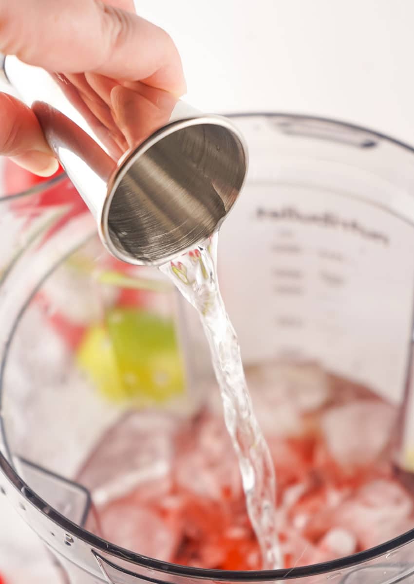 vodak being poured over ice into a blender