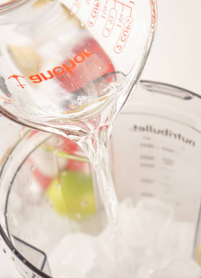 vodak being poured over ice into a blender