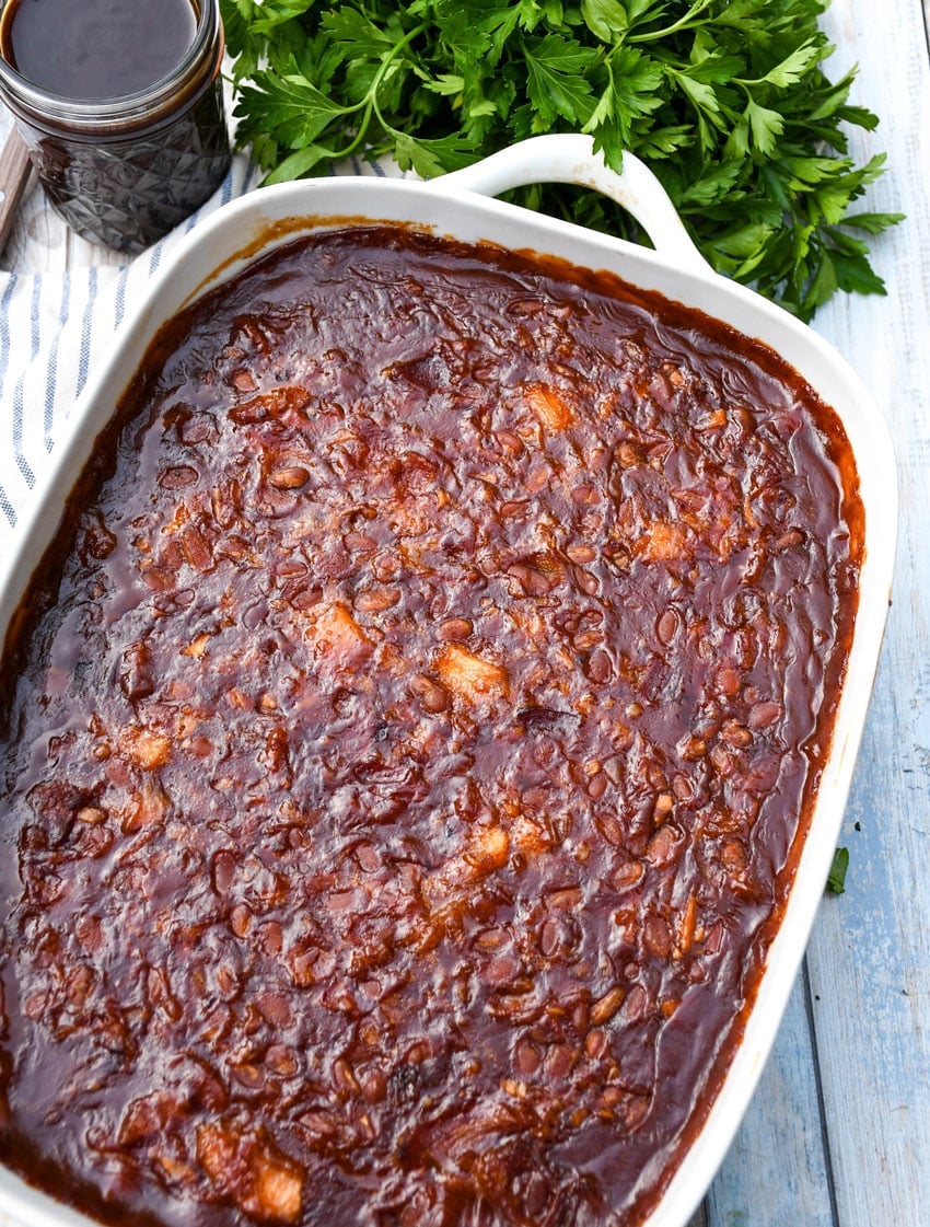 baked apple pie baked beans in a white casserole dish