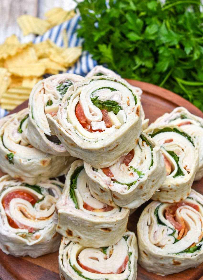 copycat costco turkey swiss pinwheels stacked on a wooden cake stand
