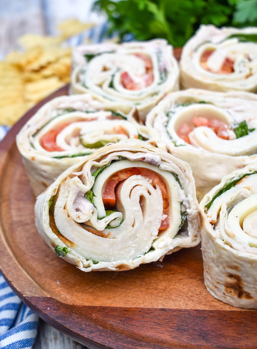 copycat costco turkey swiss pinwheels stacked on a wooden cake stand