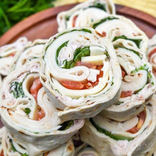 copycat costco turkey swiss pinwheels stacked on a wooden cake stand
