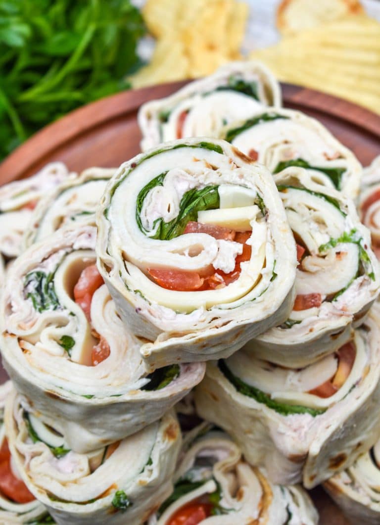 copycat costco turkey swiss pinwheels stacked on a wooden cake stand