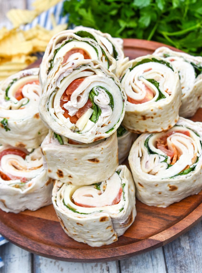 copycat costco turkey swiss pinwheels stacked on a wooden cake stand