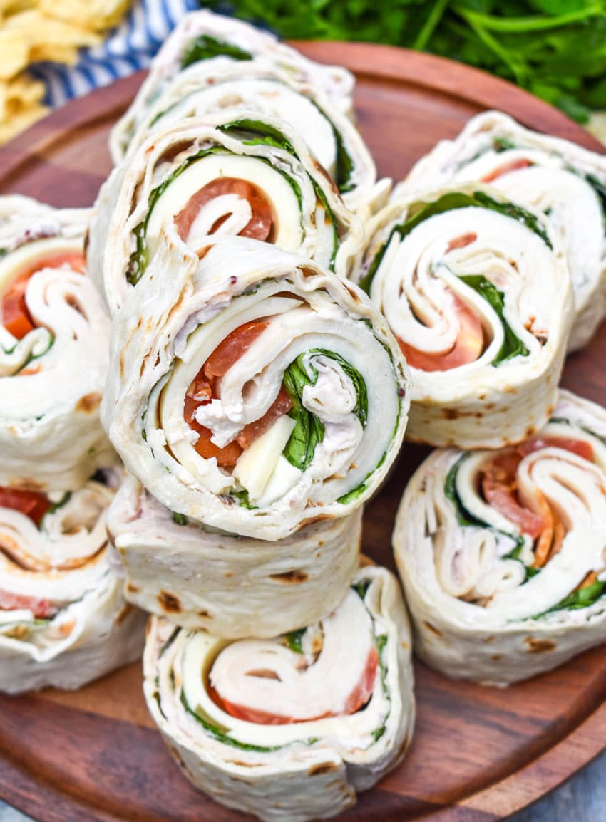 copycat costco turkey swiss pinwheels stacked on a wooden cake stand