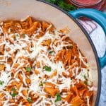 homemade hamburger helper lasagna topped with melted shredded mozzarella cheese in a large Dutch oven