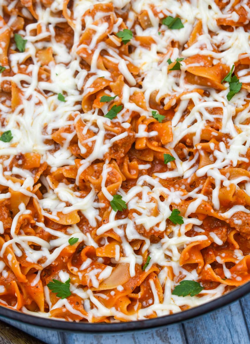 homemade hamburger helper lasagna topped with melted shredded mozzarella cheese in a large Dutch oven