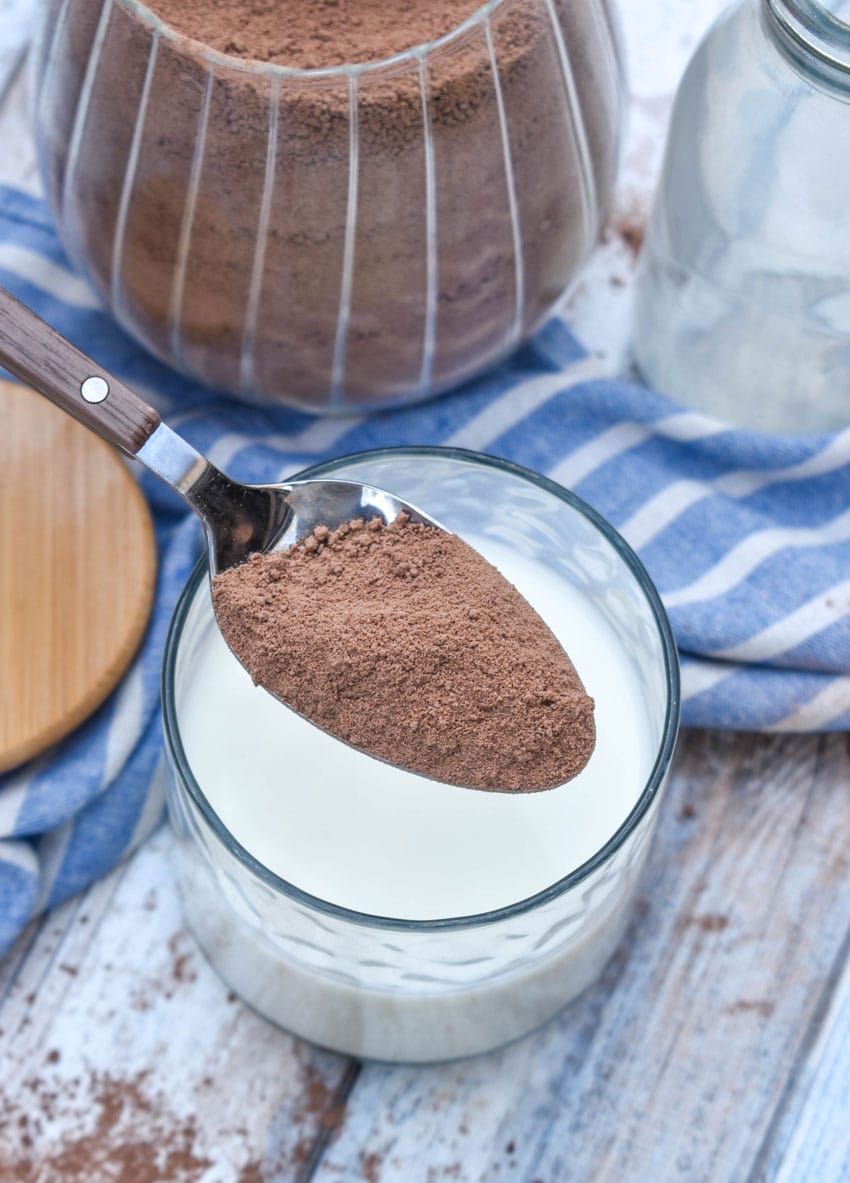 a spoon holding up a scoop of homemade nestle quik drink mix