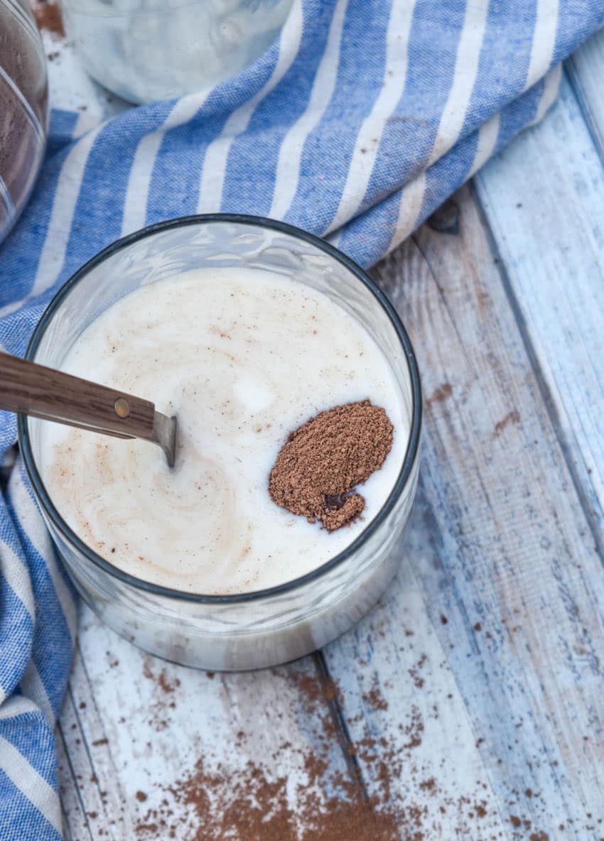 homemade nestle quik being stirred into a small glass of milk