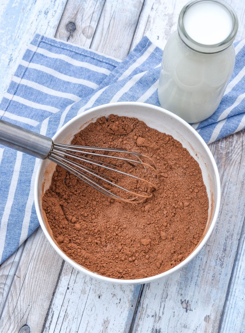 unsweetened cocoa powder and granulated sugar whisked together in a white bowl