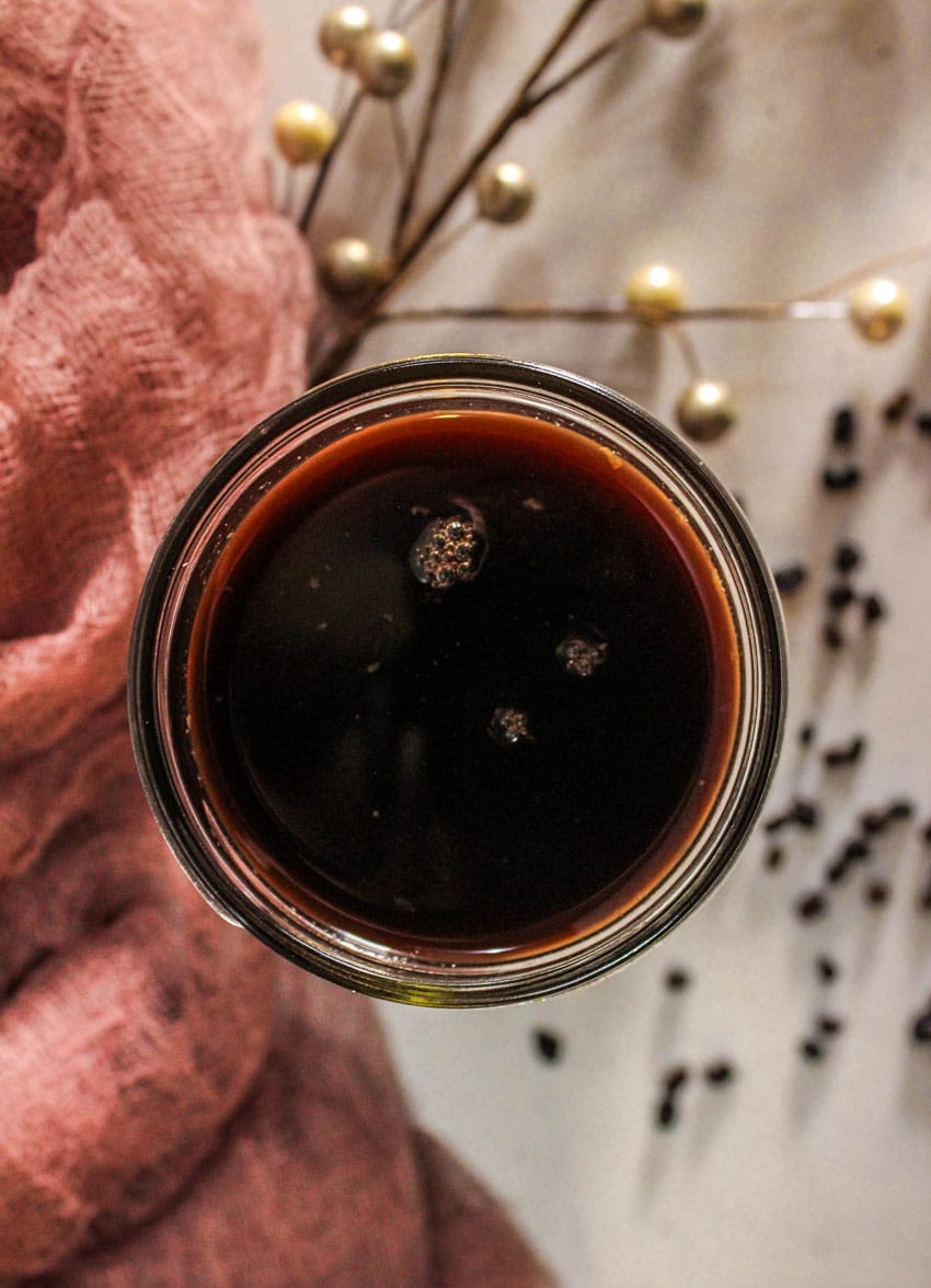 homemade elderberry syrup in a small glass jar