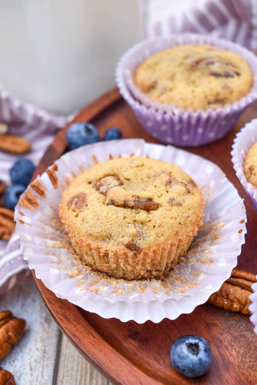 pecan pie muffins in purple paper liners on a wooden cake stand