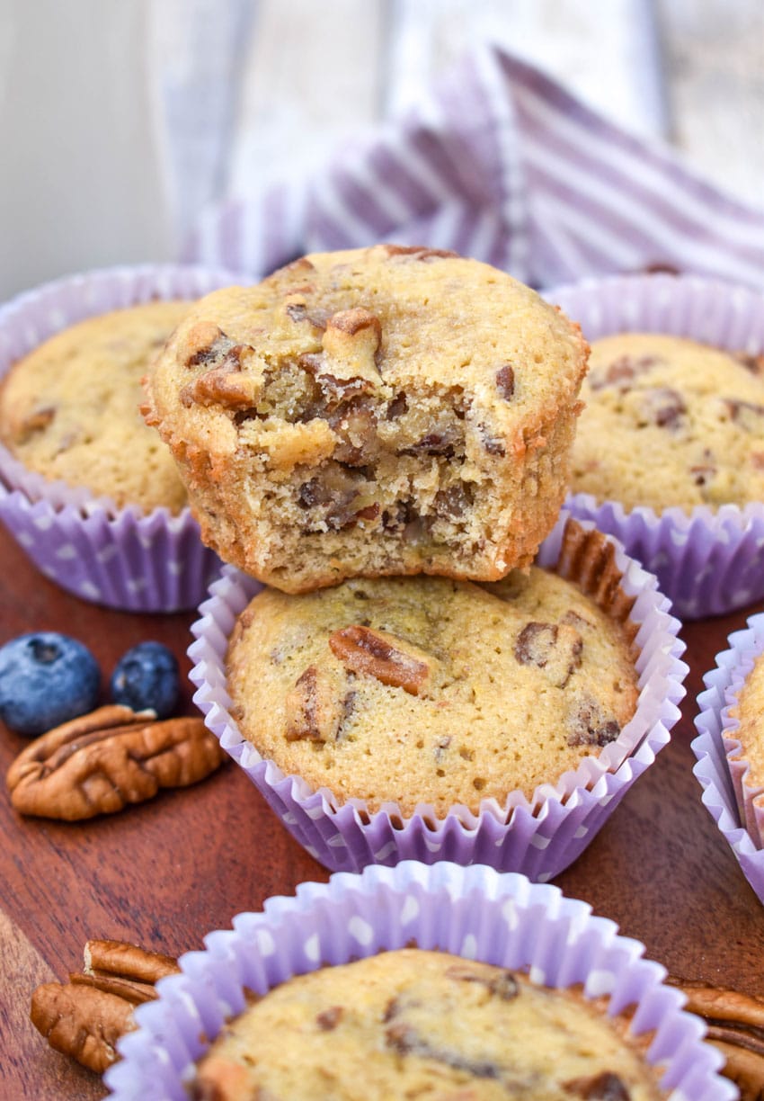 pecan pie muffins in purple paper liners on a wooden cake stand