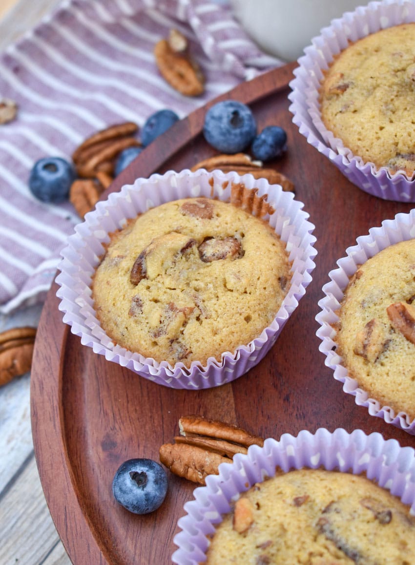 pecan pie muffins in purple paper liners on a wooden cake stand