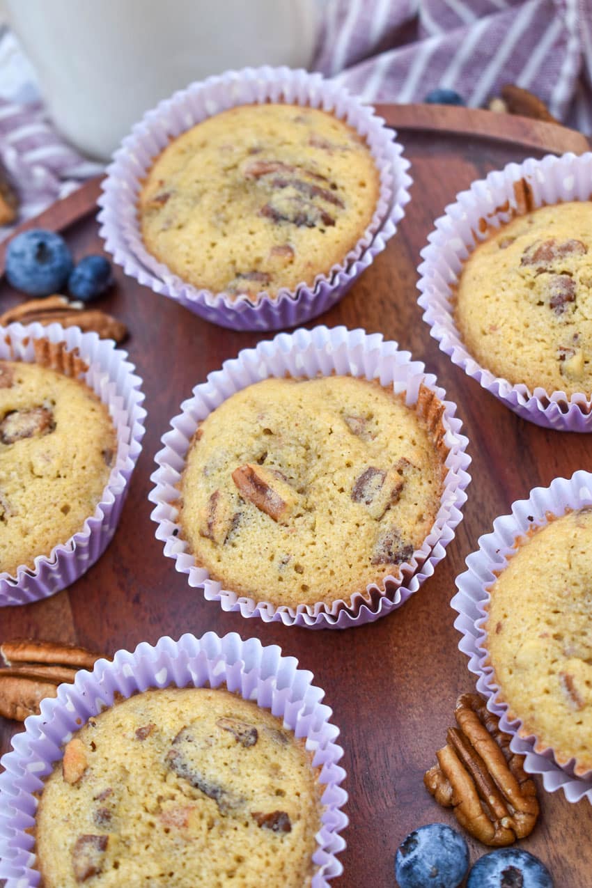 pecan pie muffins in purple paper liners on a wooden cake stand