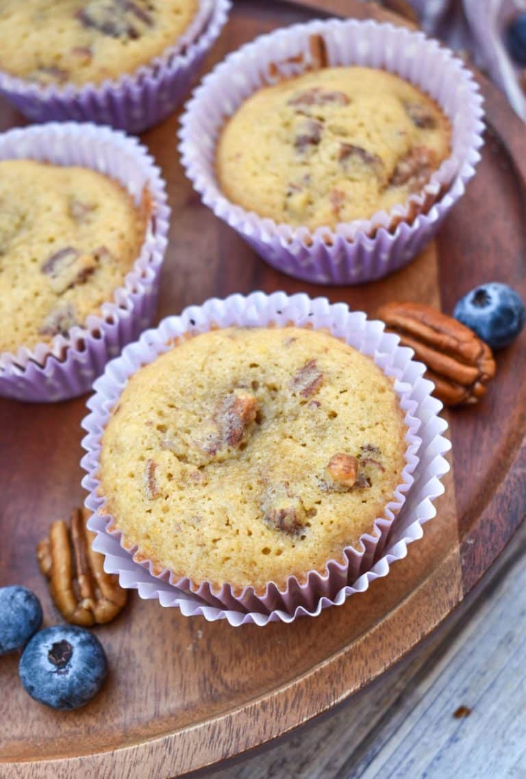 pecan pie muffins in purple paper liners on a wooden cake stand