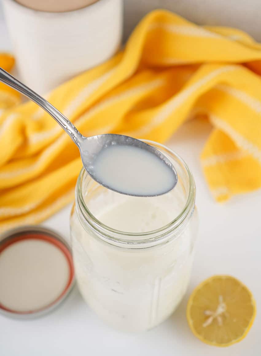 a small silver spoon holding up a scoop of homemade buttermilk