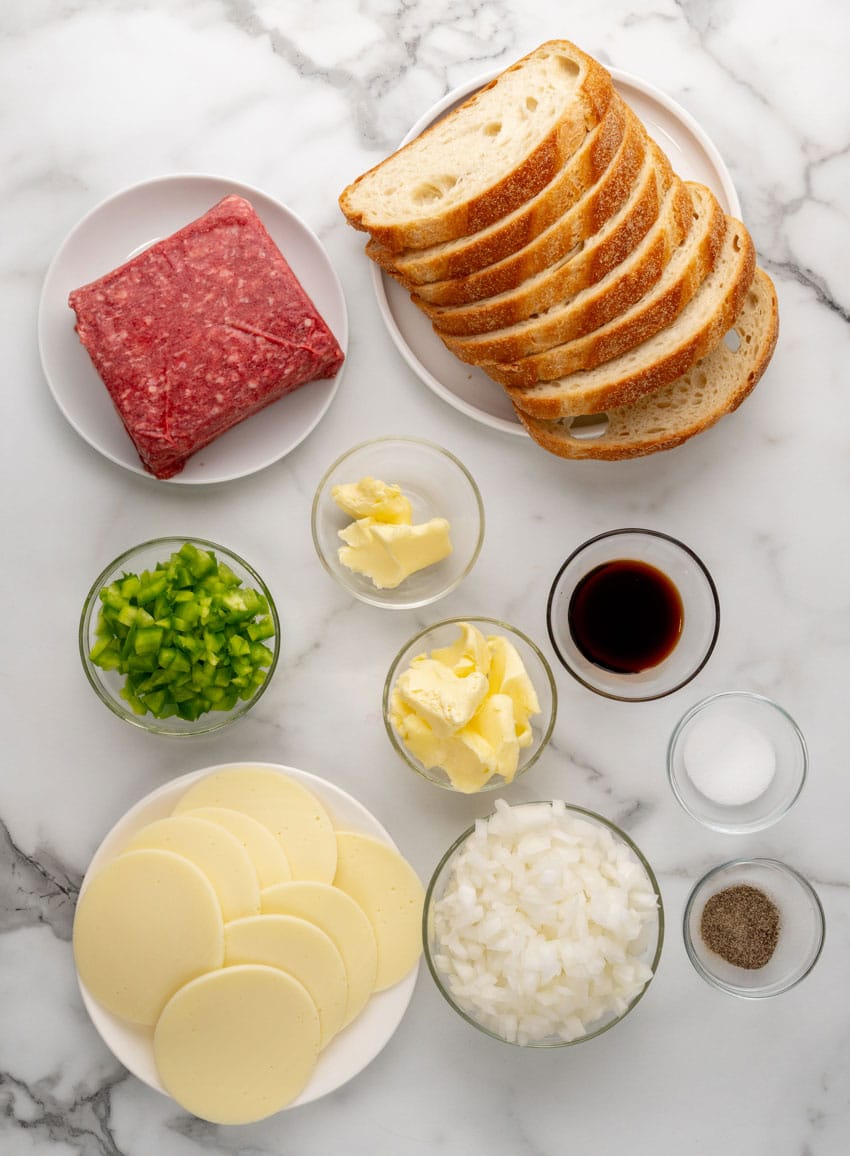 an overhead image showing the measured ingredients needed to make a batch of homemade philly cheesesteak grilled cheese sandwiches