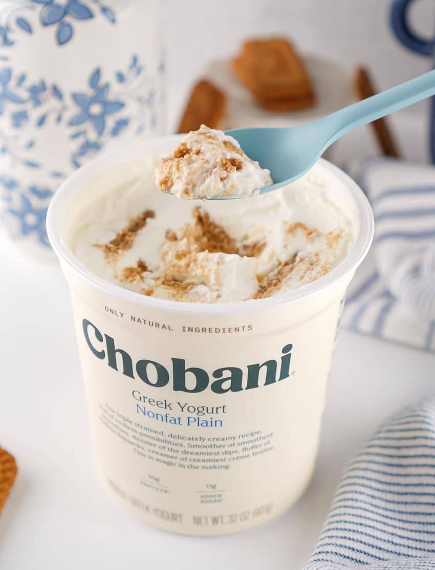 a blue plastic spoon holding up a scoop of shortcut greek yogurt japanese cheesecake