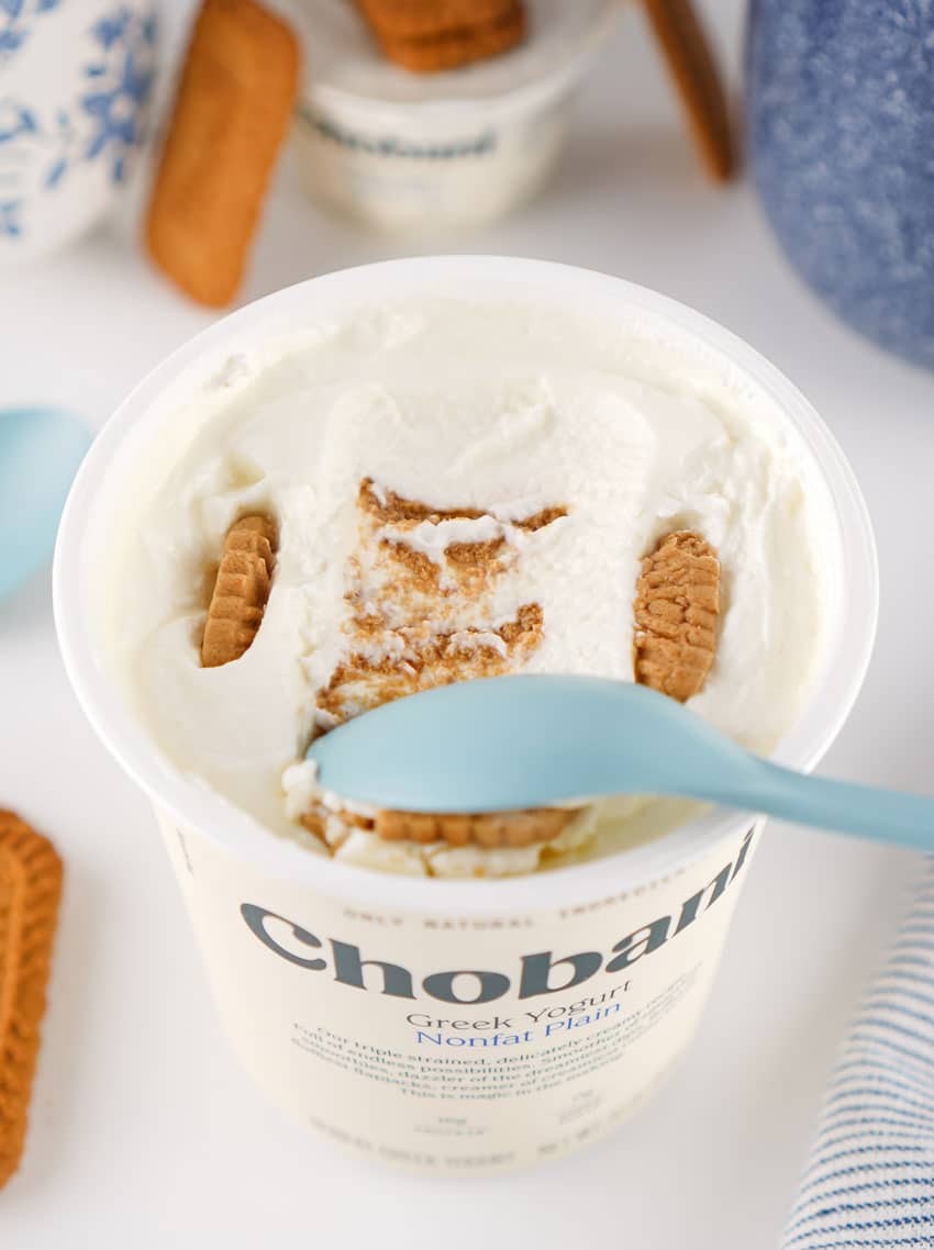 a blue plastic spoon scooping greek yogurt japanese cheesecake out of a plastic container