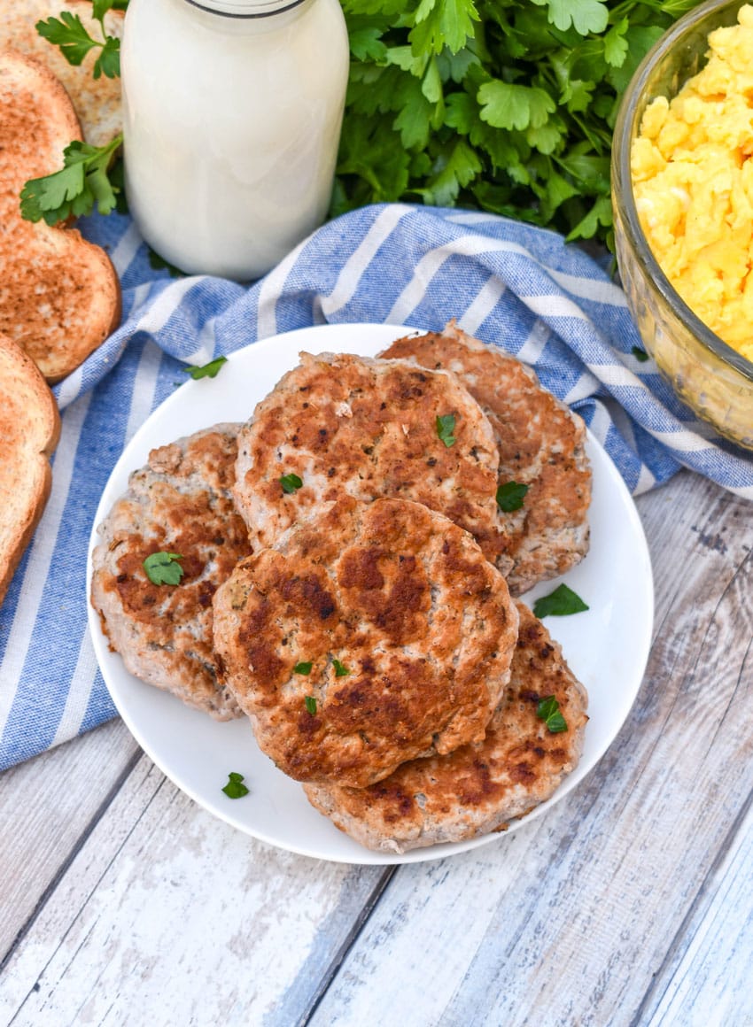 homemade breakfast sausage patties stacked on a small white plate