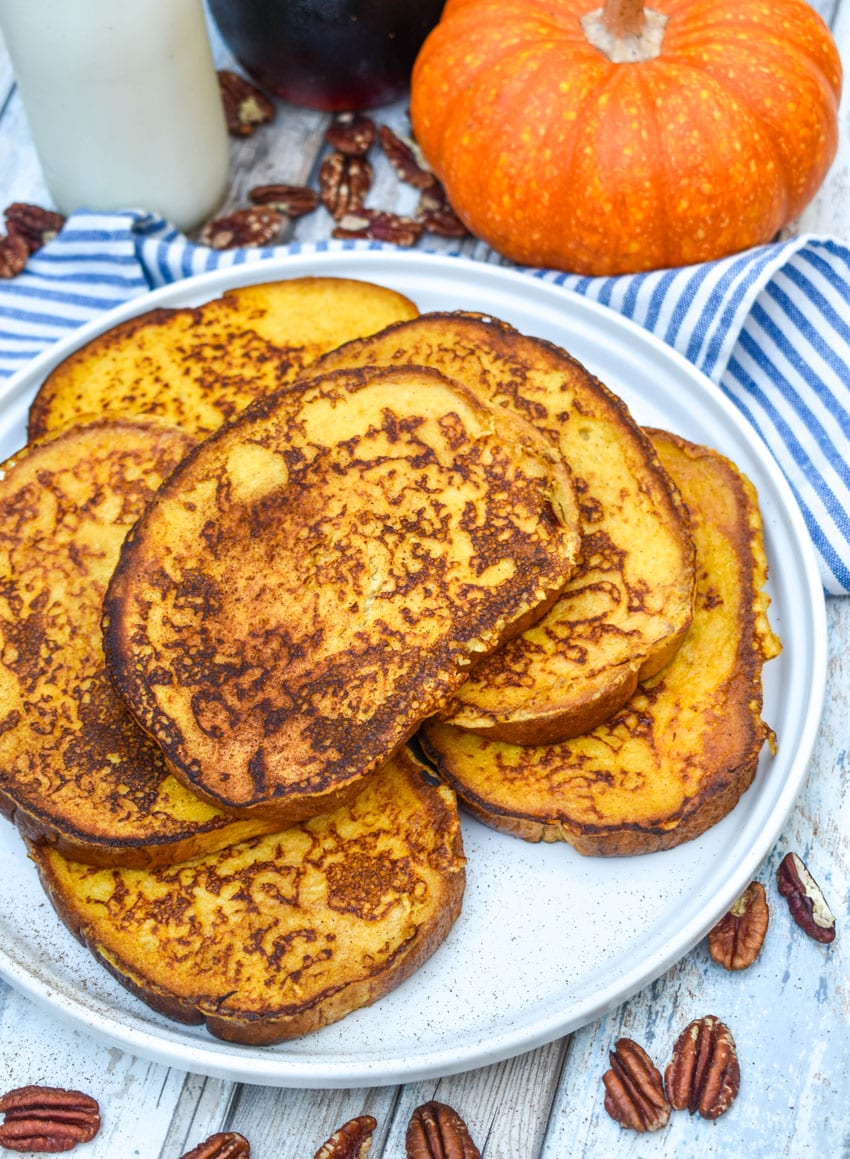 slices of pumpkin french toast stacked on a large white plate