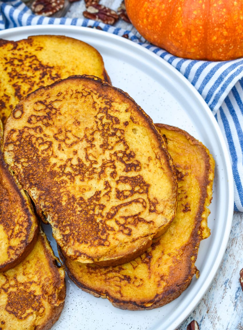 slices of pumpkin french toast stacked on a large white plate