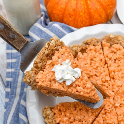 a wooden handled pie server holding up a slice of pumpkin pie rice krispie treat
